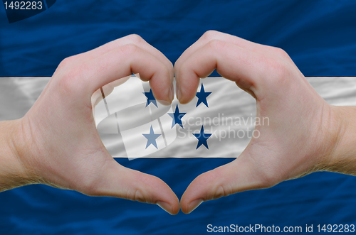 Image of Heart and love gesture showed by hands over flag of honduras bac