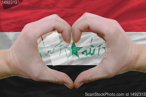 Image of Heart and love gesture showed by hands over flag of iraq backgro