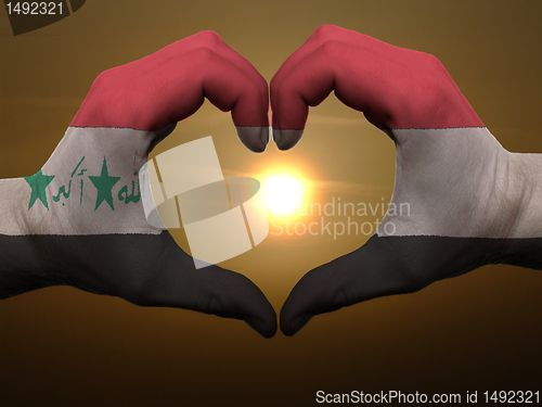 Image of Heart and love gesture by hands colored in iraq flag during beau