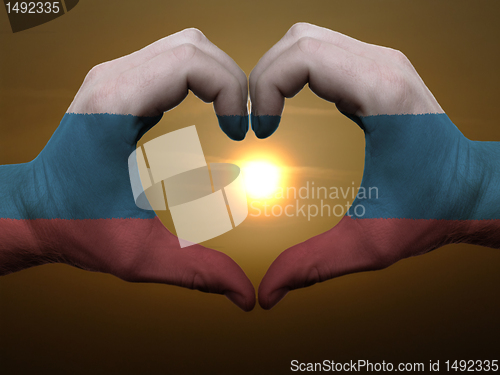 Image of Heart and love gesture by hands colored in russia flag during be