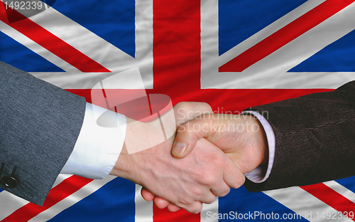 Image of businessmen handshake after good deal in front of uk flag