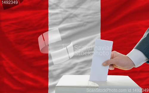 Image of man voting on elections in peru in front of flag