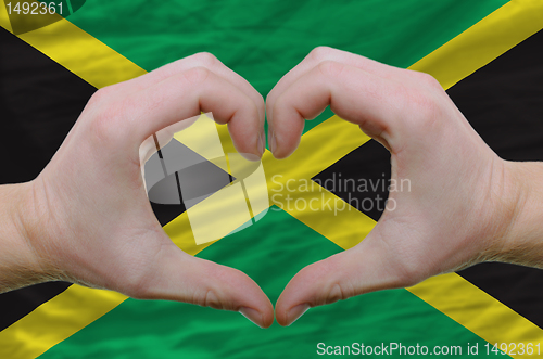 Image of Heart and love gesture showed by hands over flag of jamaica back