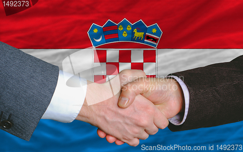 Image of businessmen handshakeafter good deal in front of croatia flag