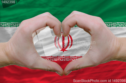Image of Heart and love gesture showed by hands over flag of iran backgro