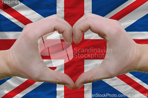 Image of Heart and love gesture showed by hands over flag of uk backgroun