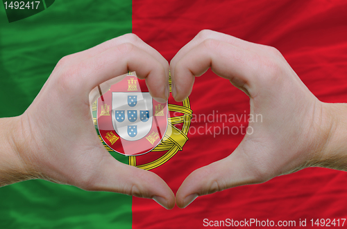 Image of Heart and love gesture showed by hands over flag of portugal bac