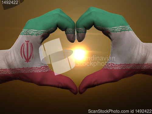 Image of Heart and love gesture by hands colored in iran flag during beau