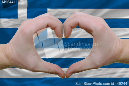 Image of Heart and love gesture showed by hands over flag of greece backg