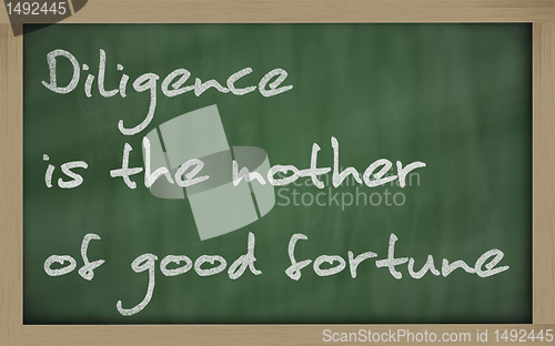 Image of " Diligence is the mother of good fortune " written on a blackbo