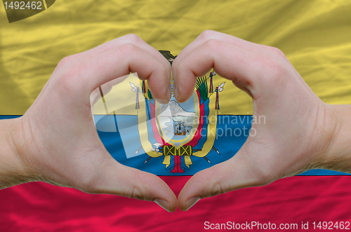 Image of Heart and love gesture showed by hands over flag of ecuador back