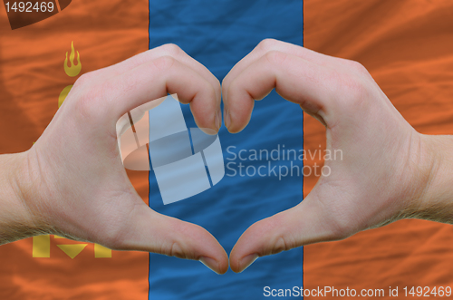 Image of Heart and love gesture showed by hands over flag of mongolia bac