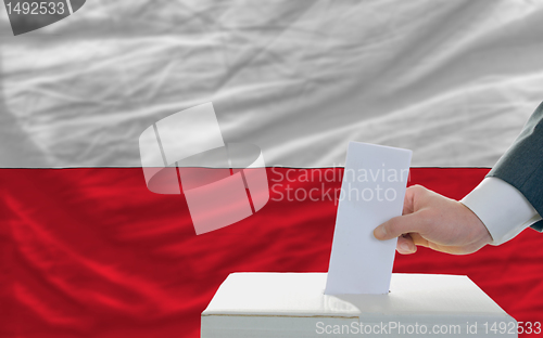 Image of man voting on elections in poland in front of flag