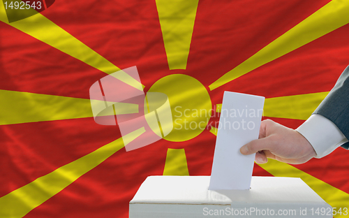 Image of man voting on elections in macedonia in front of flag