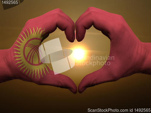 Image of Heart and love gesture by hands colored in kyrghyzstan flag duri