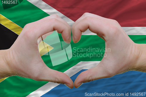 Image of Heart and love gesture showed by hands over flag of south africa