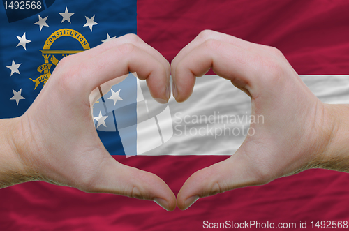 Image of Heart and love gesture showed by hands over flag of georgia back