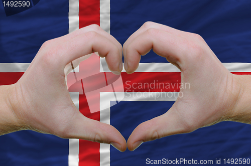 Image of Heart and love gesture showed by hands over flag of iceland back