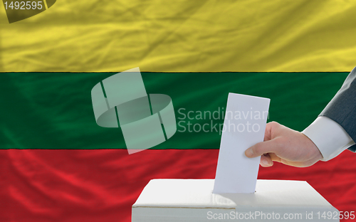 Image of man voting on elections in lithuania in front of flag