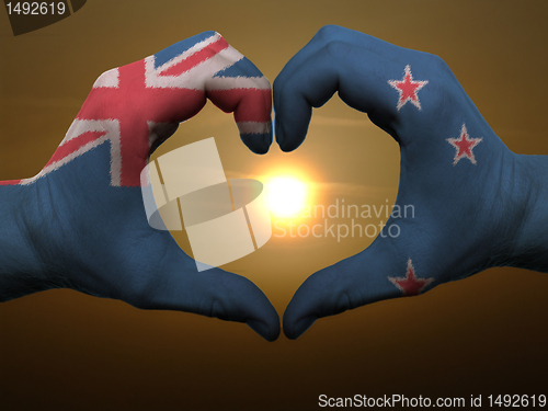 Image of Heart and love gesture by hands colored in new zealand flag duri