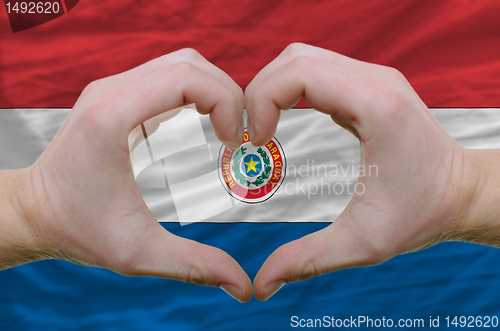 Image of Heart and love gesture showed by hands over flag of paraguay bac
