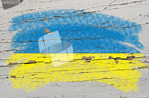 Image of flag of ukraine on grunge wooden texture painted with chalk  