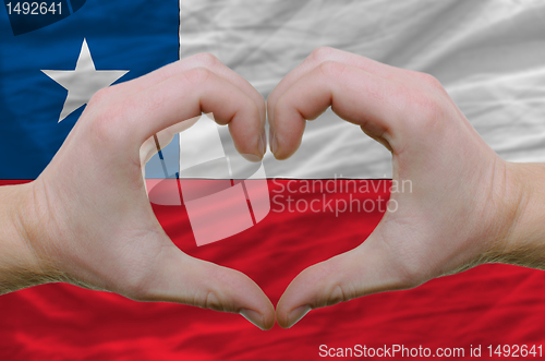 Image of Heart and love gesture showed by hands over flag of chile backgr