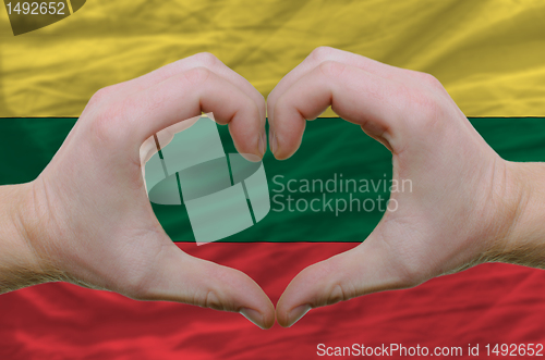 Image of Heart and love gesture showed by hands over flag of lithuania ba