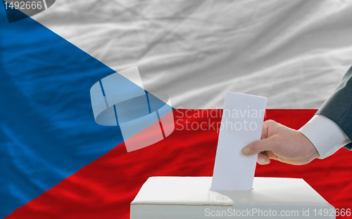Image of man voting on elections in czech in front of flag