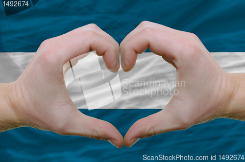 Image of Heart and love gesture showed by hands over flag of el salvador 