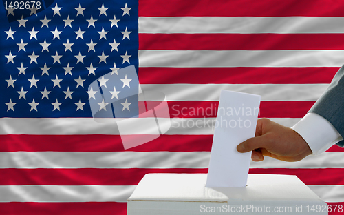 Image of man voting on elections in america in front of flag