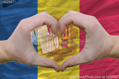 Image of Heart and love gesture showed by hands over flag of Andora backg