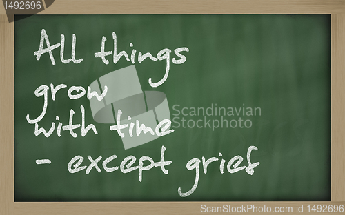 Image of " All things grow with time - except grief " written on a blackb