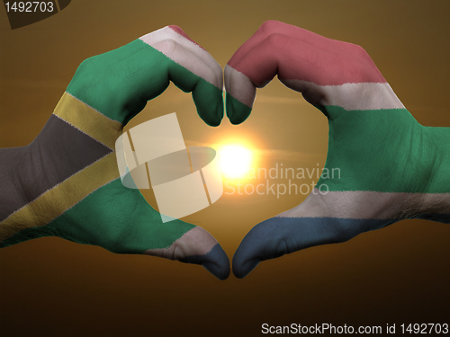 Image of Heart and love gesture by hands colored in south africa flag dur