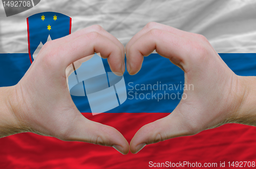 Image of Heart and love gesture showed by hands over flag of slovenia bac