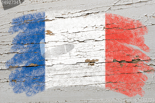 Image of flag of France on grunge wooden texture painted with chalk  