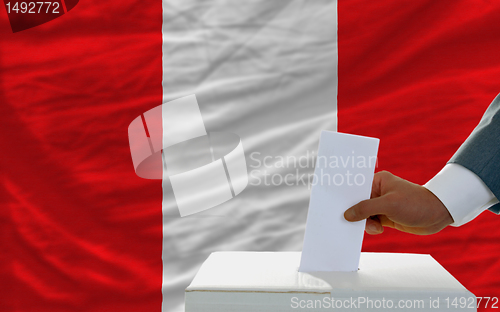 Image of man voting on elections in peru in front of flag