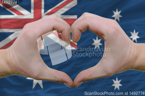 Image of Heart and love gesture showed by hands over flag of Australia ba