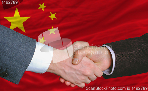 Image of businessmen handshakeafter good deal in front of china flag