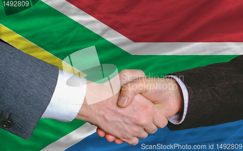 Image of businessmen handshake after good deal in front of south africa f