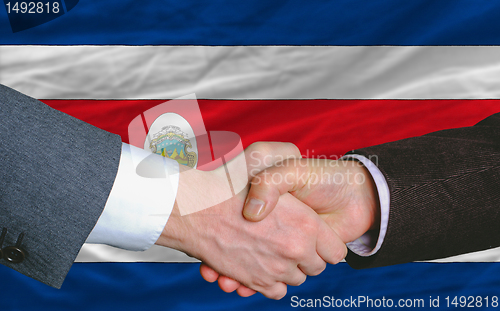 Image of businessmen handshakeafter good deal in front of costarica flag