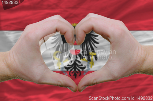 Image of Heart and love gesture showed by hands over flag of Austria back