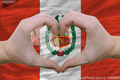 Image of Heart and love gesture showed by hands over flag of peru backgro