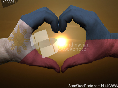 Image of Heart and love gesture by hands colored in phillipines flag duri