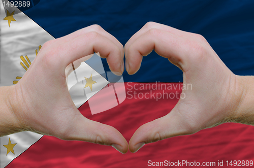 Image of Heart and love gesture showed by hands over flag of phillipines 