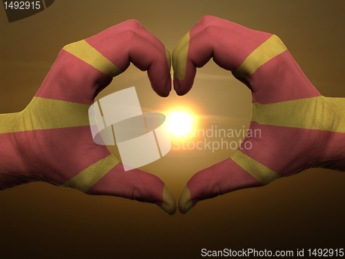 Image of Heart and love gesture by hands colored in macedonia flag during