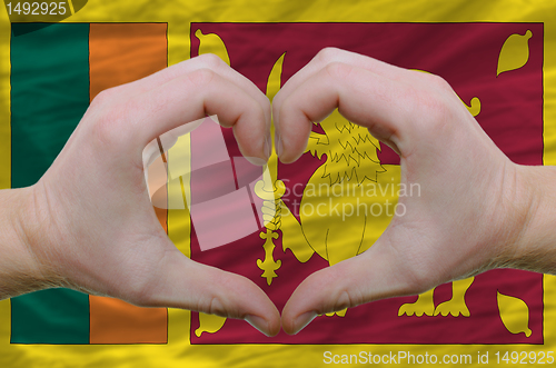 Image of Heart and love gesture showed by hands over flag of sri lanka 