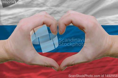 Image of Heart and love gesture showed by hands over flag of russia backg