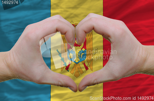 Image of Heart and love gesture showed by hands over flag of moldova back