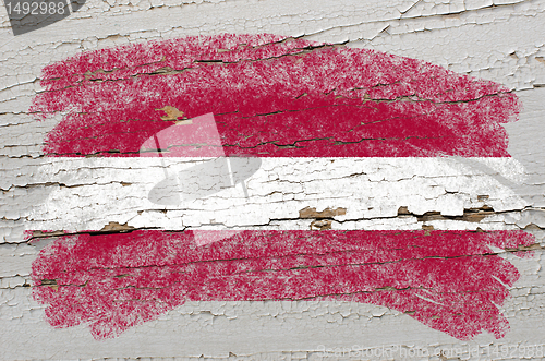 Image of flag of latvia on grunge wooden texture painted with chalk  